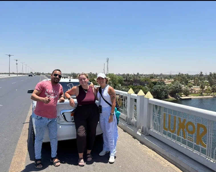 Tito with travellers at the Luxor sign on the Nile bridge